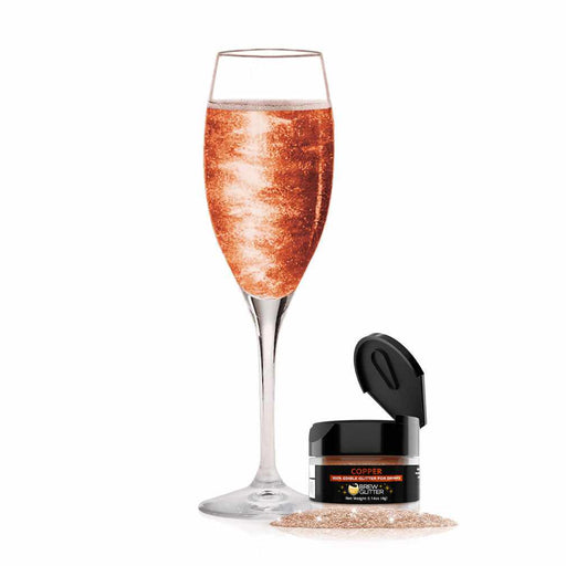 product shot of bronze glitter drink in a flute glass next to a jar