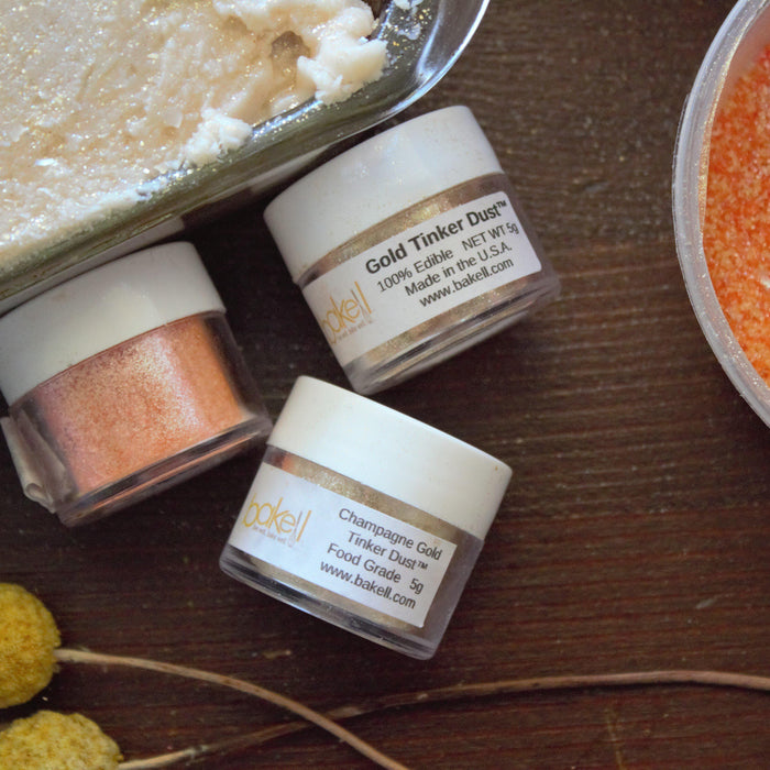 Gold and champagne edible glitter dust, orange sprinkles, and a dessert with gold shimmer.
