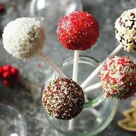 Festive Christmas cake pops with white, red, and chocolate sprinkles, arranged in a glass jar.