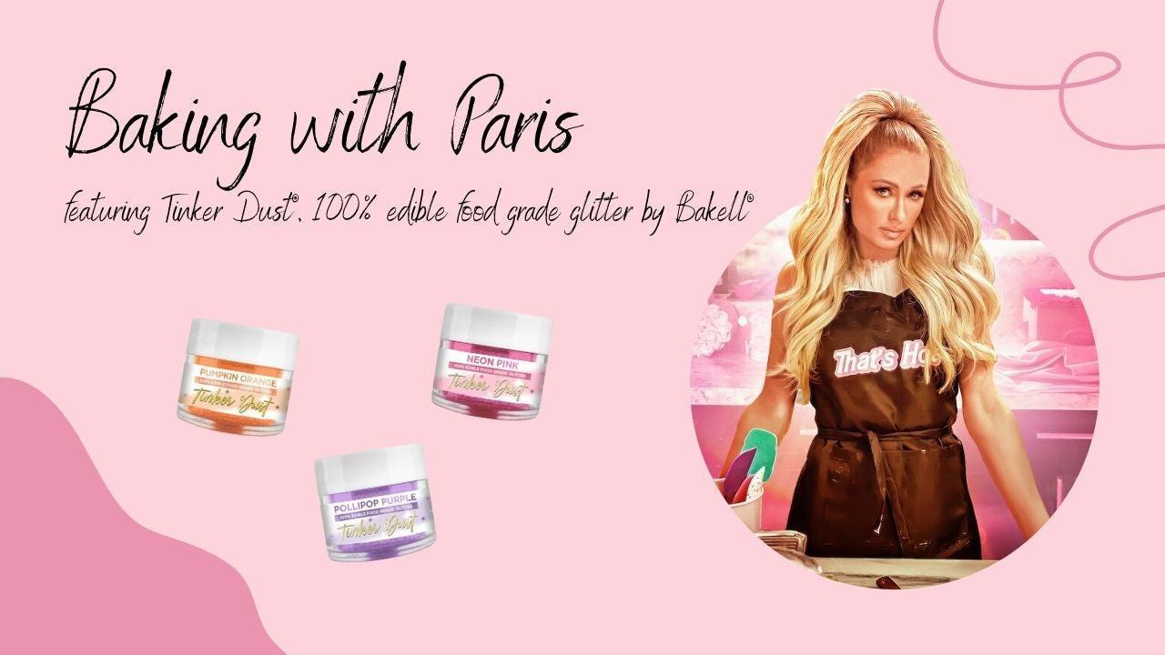 Paris Hilton in a brown apron next to three jars of colorful Tinker Dust edible glitter.