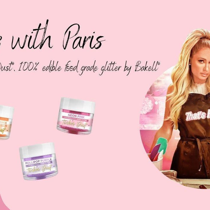 Paris Hilton in a brown apron next to three jars of colorful Tinker Dust edible glitter.