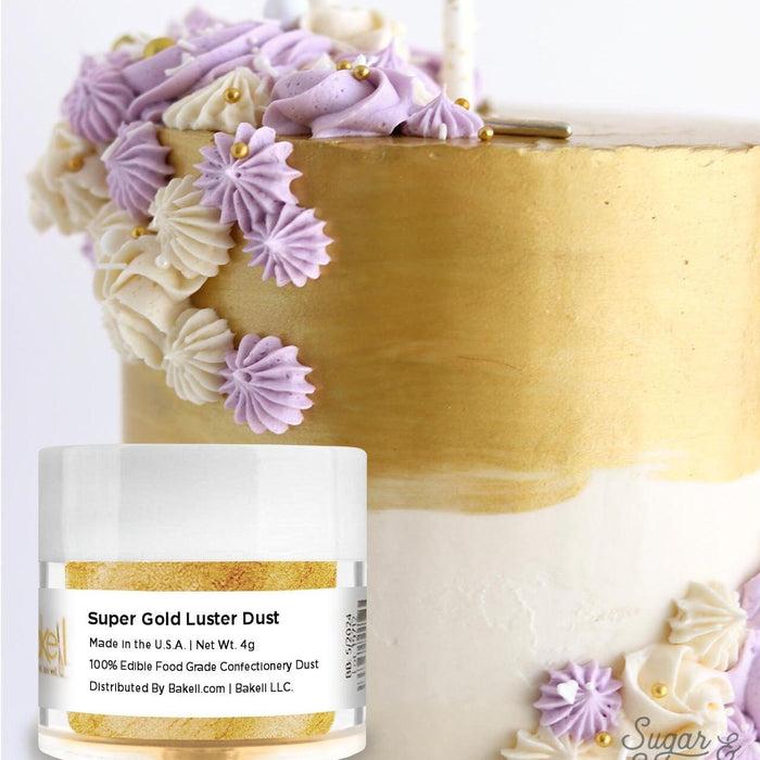 Gold luster dust jar next to a white and gold cake with purple and cream frosting swirls.