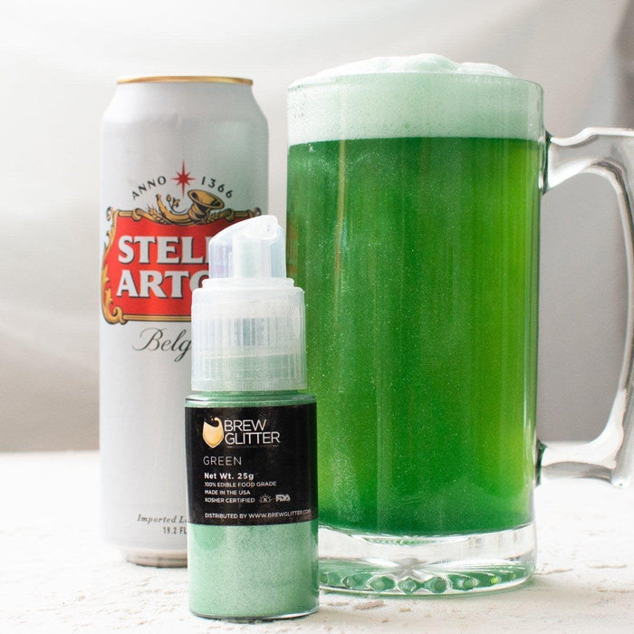 A can of Stella Artois next to a mug of green beer and a bottle of green edible glitter.