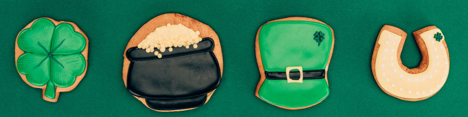 St. Patrick's Day cookies: green shamrock, black pot of gold, green leprechaun hat, and white horseshoe.