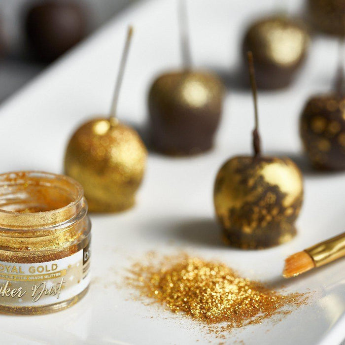 Royal Gold Tinker Dust edible glitter next to a brush and chocolate-dipped treats.