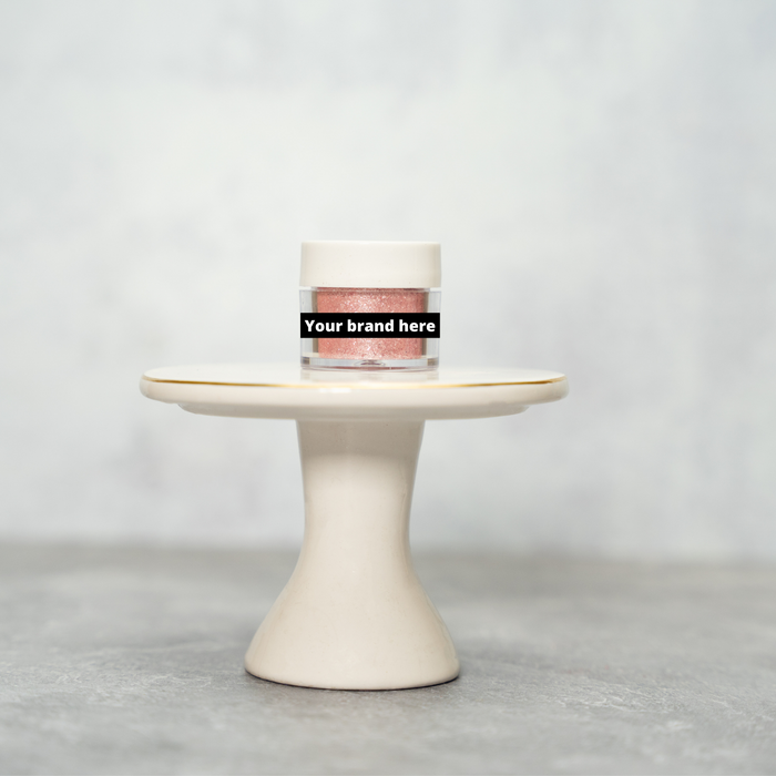 Pink glitter powder in a clear jar with a white lid, displayed on a small white pedestal.
