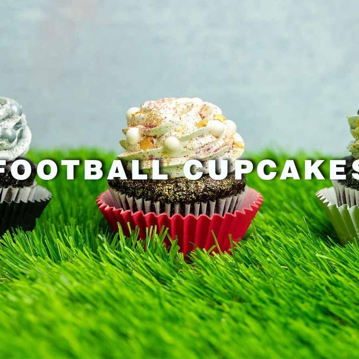 Three football-themed cupcakes with green, white, and gold frosting and sprinkles on artificial grass.
