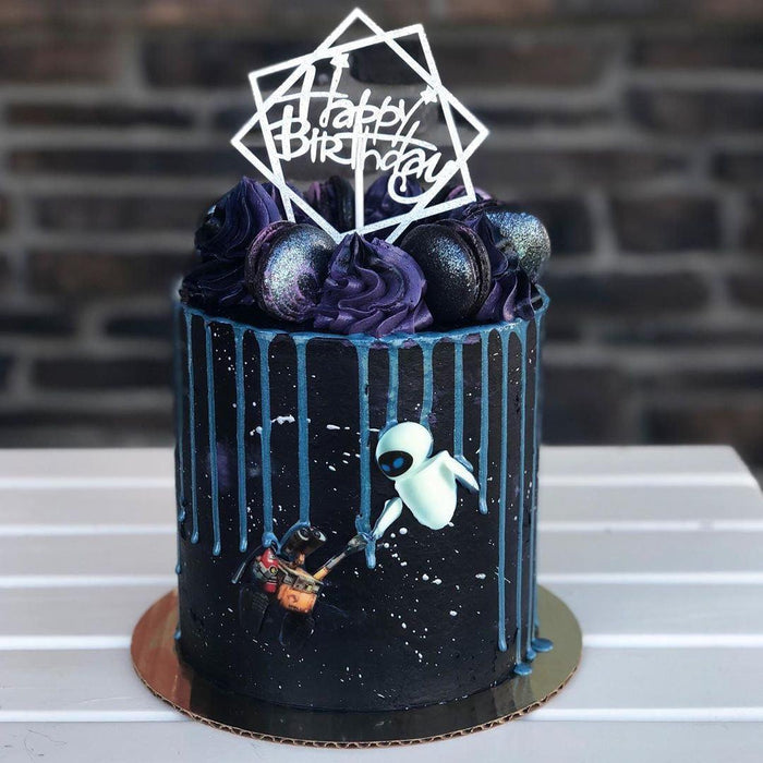 Dark blue birthday cake with Wall-E and EVE characters, purple frosting, macarons, and blue drip icing.