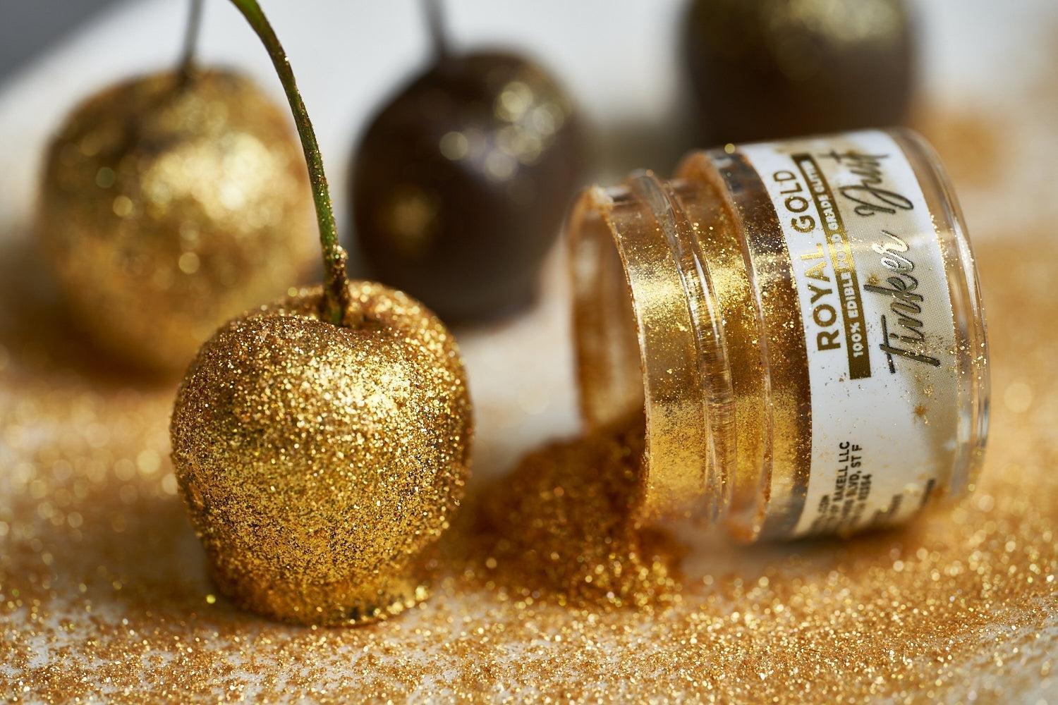 Gold glitter-covered cherry next to an open jar of "Royal Gold" edible glitter.