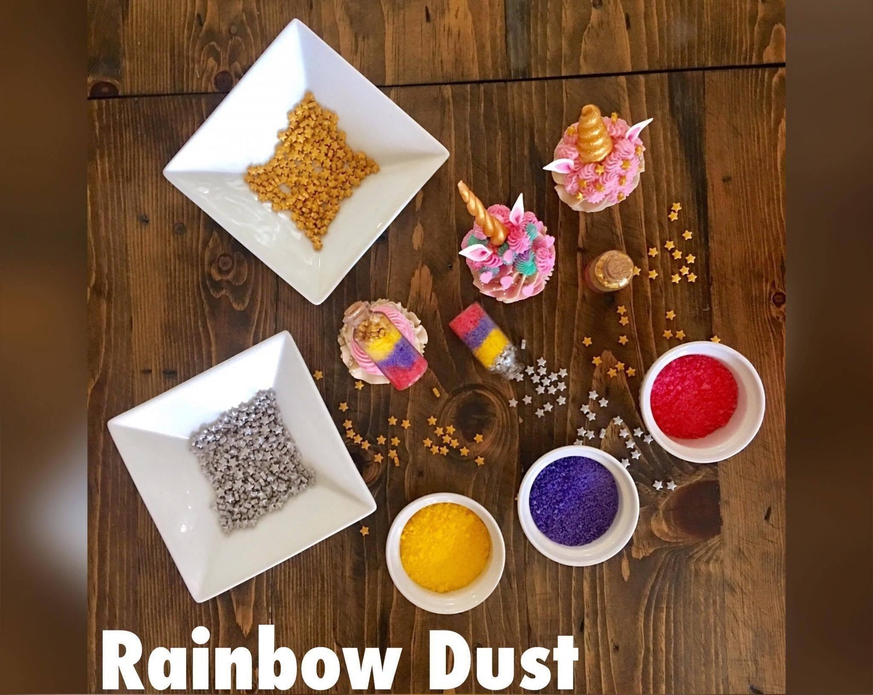 Unicorn cupcakes, colorful sprinkles, and edible glitter for baking on a wooden table.