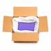 Open cardboard box filled with a white bag containing 132lb of Baby Violet ultrafine iridescent craft glitter.