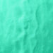 Close-up of vibrant, ultrafine UV reactive iridescent craft glitter in a bright teal color.