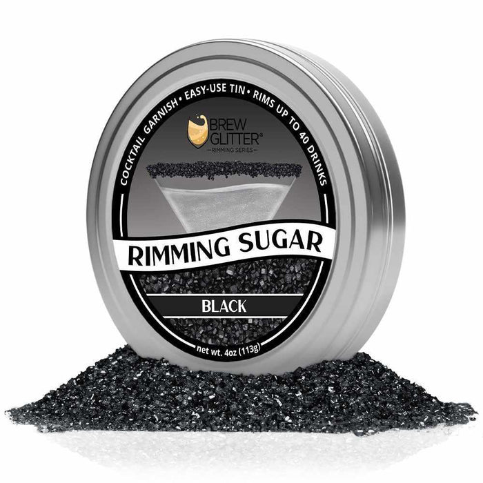 Brew Glitter Black Rimming Sugar in a silver tin, surrounded by a pile of black sugar crystals.