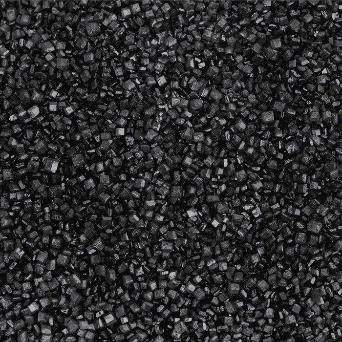 Close-up texture of coarse, sparkling black cocktail rimming sugar crystals for garnishing glassware.