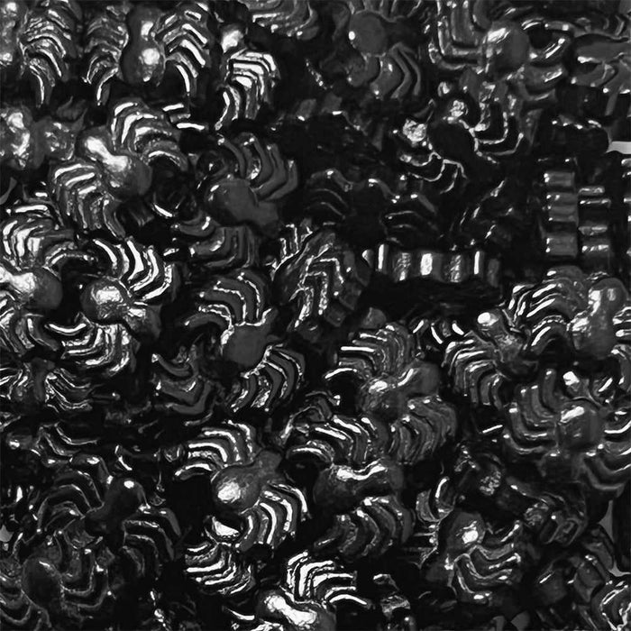 Pile of shiny black spider-shaped sprinkles for baking and decorating.