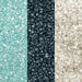 Close-up of three vertical sections of sparkling cocktail rimming sugar: light blue, dark grey, and white.