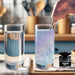 Hand stirring blue iridescent Brew Glitter into a glass of water, creating a holographic, shimmery effect.