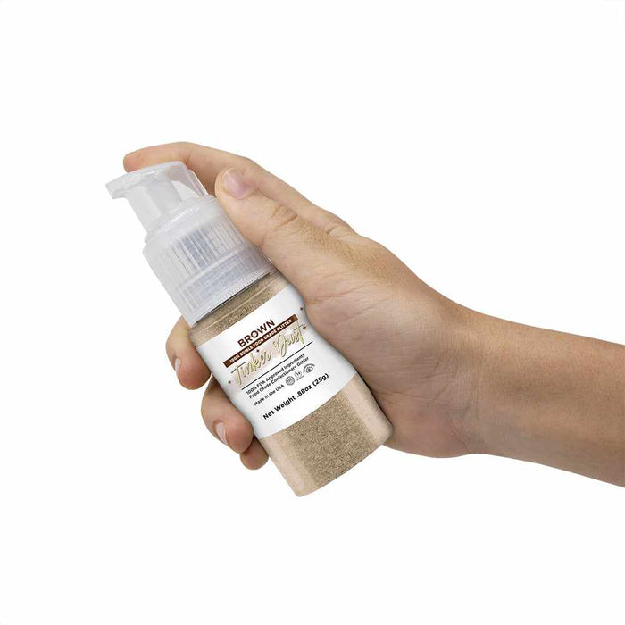 Front View of a hand holding a 25 gram Brown Edible Glitter Spray Pump. | bakell.com