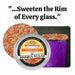 Candy Corn Rimming Sugar in a 4oz tin, with orange, yellow, and white sprinkles on a glass rim.