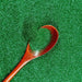 Christmas Green Ultrafine Metallic Craft Glitter Dazzler Dust in a wooden spoon, on a bed of glitter.