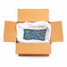 Open cardboard box filled with 132lb of chunky rainbow holographic craft glitter in a white bag.