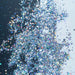 Chunky rainbow holographic hexagon mix craft glitter, sparkling on a black and white background.