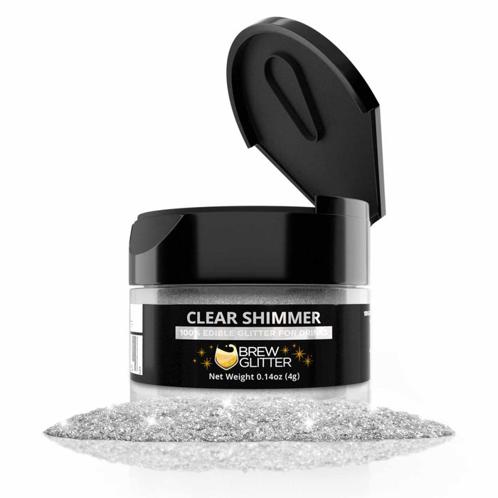 4g jar of Clear Shimmer edible drink glitter with a black flip-top cap and a pile of sparkling silver powder.