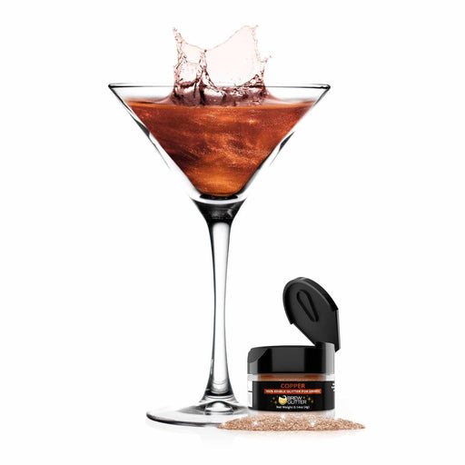 product shot of martini glass filled with copper glitter drink next to a jar