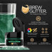 Dark green Brew Glitter® edible drink glitter in a jar next to a glass with glittered liquid.