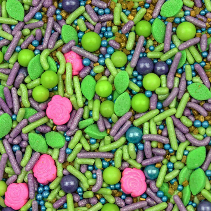 Product swatch of sprinkles mix with pink rose shapes, blue purple pink & green beads, gold sugar rock, and purple & green jimmies