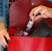 A close up of a woman's hand, putting Fuchsia Edible Drink Glitter in her purse. | bakell.com