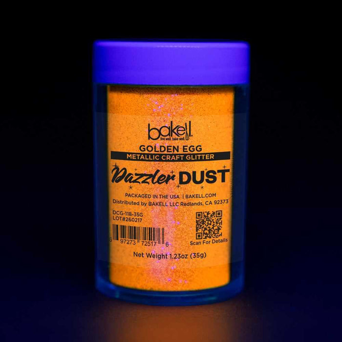 Bakell Golden Egg metallic craft glitter Dazzler Dust in a clear jar with a purple lid, glowing under UV light.