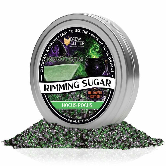 Hocus Pocus Halloween cocktail rimming sugar in a silver tin with a pile of green and purple sugar crystals below.