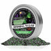 Hocus Pocus Halloween cocktail rimming sugar in a silver tin with a pile of green and purple sugar crystals below.