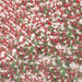 Close-up of sparkling red, green, and white holiday rimming sugar crystals.