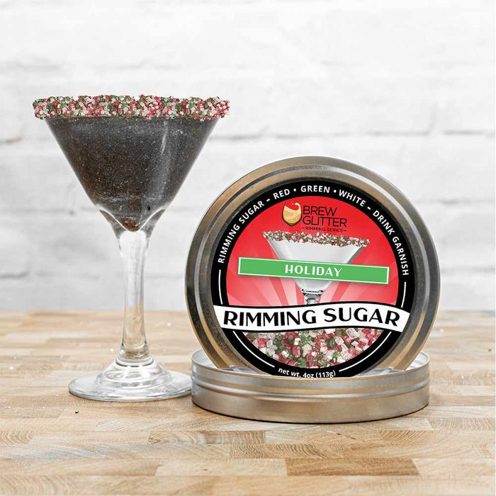Holiday Rimming Sugar tin with red, green, and white sprinkles, next to a martini glass garnished with the sugar.