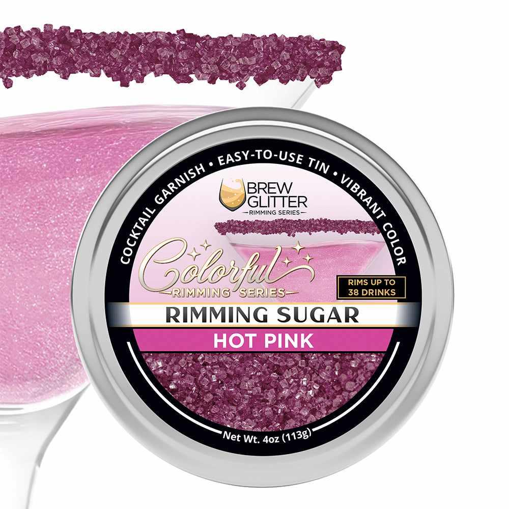 Hot pink cocktail rimming sugar in a 4oz tin next to a martini glass rimmed with vibrant pink sugar crystals.