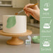 Hand painting a white cake with a green leaf design using Leaf Green Luster Dust.