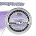 Light purple pearl rimming sugar in a round aluminum tin, with a cocktail glass rimmed with sugar in the background.