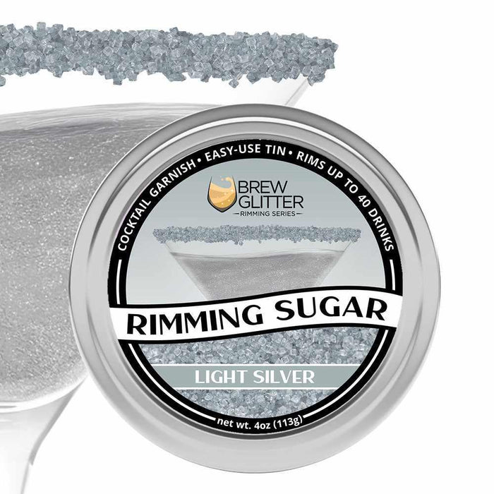 Light silver rimming sugar in a 4oz tin, with a martini glass rimmed with the sugar in the background.