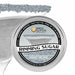 Light silver rimming sugar in a 4oz tin, with a martini glass rimmed with the sugar in the background.