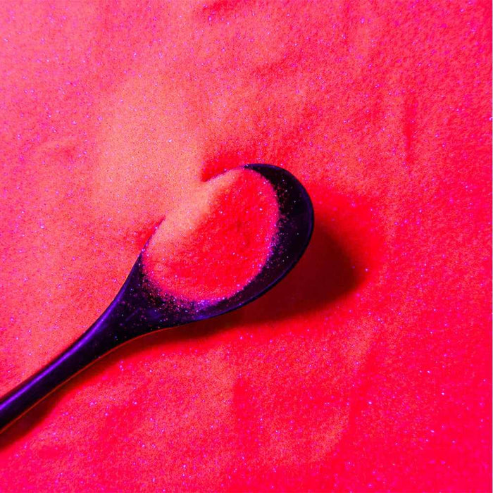 Miami Orange Ultrafine UV Reactive Iridescent Craft Glitter Dazzler Dust on a black spoon.