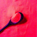 Miami Orange Ultrafine UV Reactive Iridescent Craft Glitter Dazzler Dust on a black spoon.