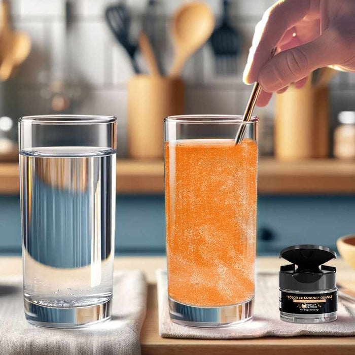 Hand stirring orange color-changing brew glitter into a tall glass of water next to a clear glass and a glitter jar.