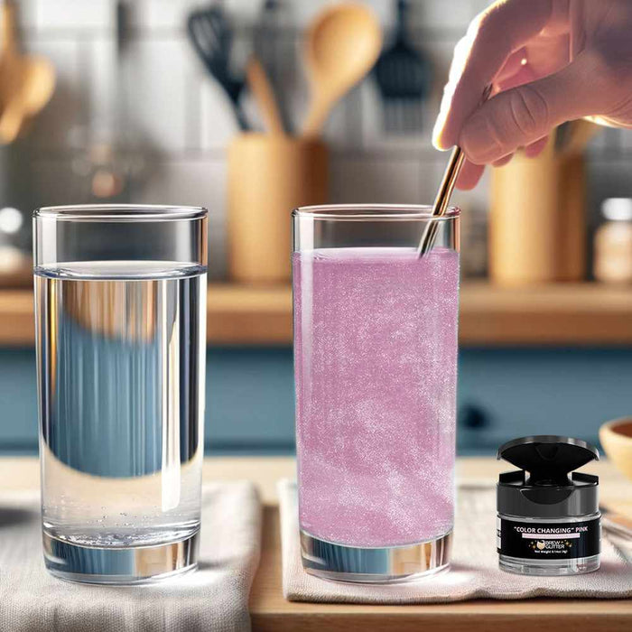 Hand stirring white-to-pink color changing brew glitter into a clear drink, next to a plain glass of water.