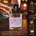 Pink iridescent edible glitter being poured into a glass of liquid, showing a shimmering holographic effect.