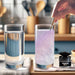 Hand stirring pink iridescent edible glitter into a glass of water next to a jar of Brew Glitter.