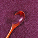 Plum purple ultrafine metallic craft glitter with a wooden spoon scooping it.