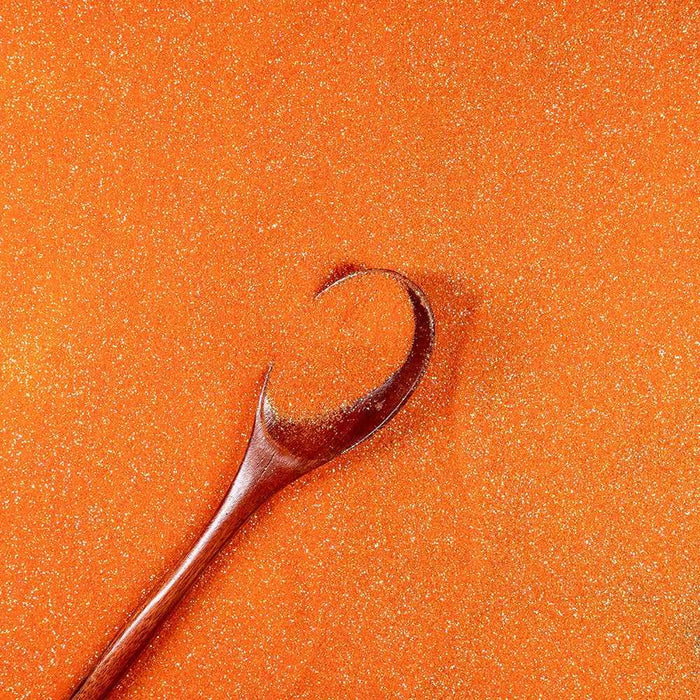 Pumpkin Orange Ultrafine Iridescent Craft Glitter Dazzler Dust, premium polyester, with a wooden spoon.