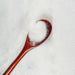 White iridescent craft glitter on a wooden spoon, surrounded by more glitter.